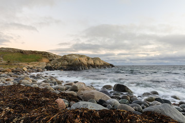 Pebble shore and rocks by the sea at Hove, Tromoy in Arendal, Norway. Raet National Park. Long exposure.