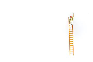 Miniature people: Worker with ladder on white background and copy space using as background business concept. © keatikun