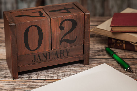 Perpetual Calendar in desk scene with blank diary page, January 2nd