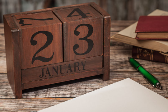Perpetual Calendar in desk scene with blank diary page, January 23rd