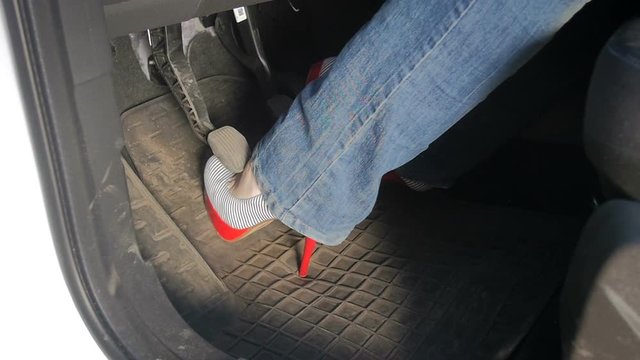 Slow Motion Footage Of Woman In Sexy High Heels Pressing Car Pedals While Driving Car. Unsuatable And Uncomfortable Shoes For Driving Automobile