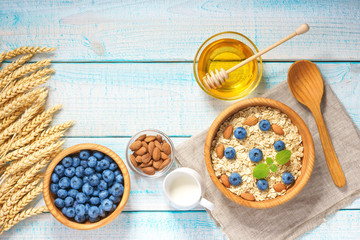 Healthy breakfast with oat flakes, natural milk, fresh blueberries. Top view.