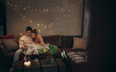 Couple relaxing with smartphone in cozy living room