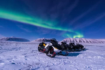 Fotobehang The polar arctic Northern lights aurora borealis sky star in Norway Svalbard in Longyearbyen city snowmobile the moon mountains © bublik_polina