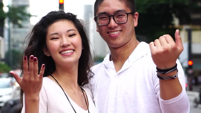 Young Asian Couple Inviting Someone to Come