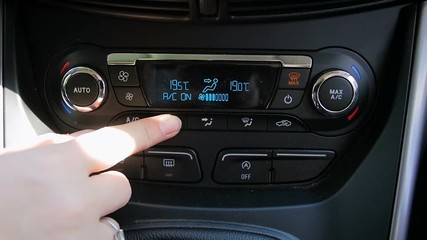 Closeup slow motion footage of drivers hand adjusting temperature and turning off car climate control