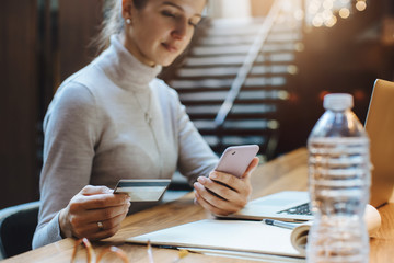 Business woman using credit card and smartphone for shopping in internet