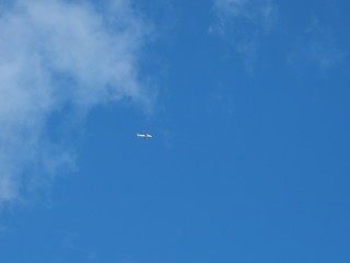Striped pattern white clouds on blue sky with plane, The Hague 2017