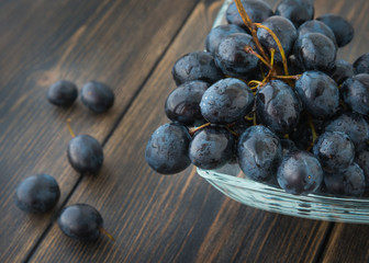 Wet ripe dark grapes - vine grape - in a glass bowl