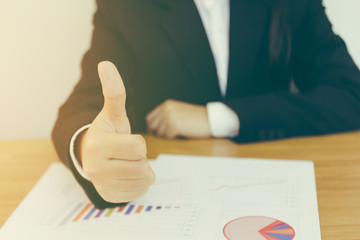 businesswoman hand show thumb up on data report chart