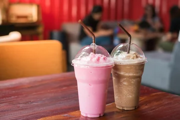 Zelfklevend Fotobehang Pink milk and cocoa on table in cafe  © naviya