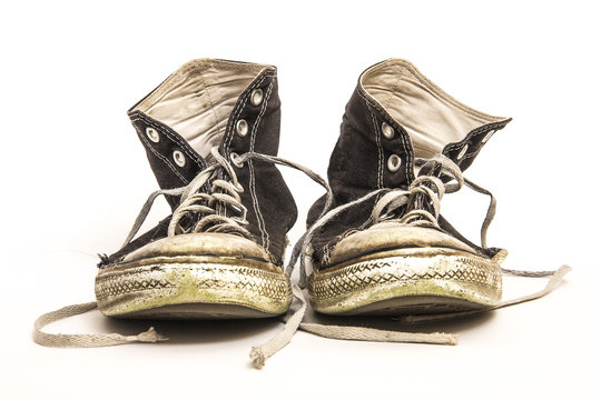 Pair of Men's or Teenager's Worn Out Dirty High Top Black and White Athletic Tennis Shoes Isolated on White Background