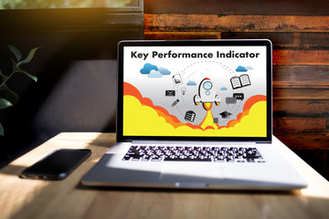 KPI acronym (Key Performance Indicator) Business team hands at work with financial reports and a laptop