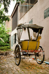 Fototapeta na wymiar Traditional Thai transport - old yellow trishaw on a street. Chiang Mai, Thailand.
