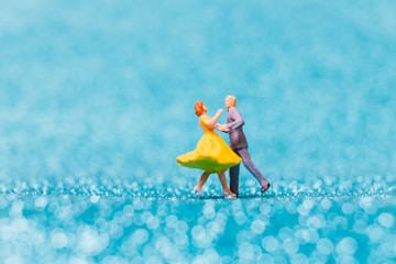 Miniature people , Couple dancing on blue glitter background , Valentine's day concept