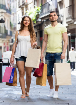 happy  young pair with shopping bags at city