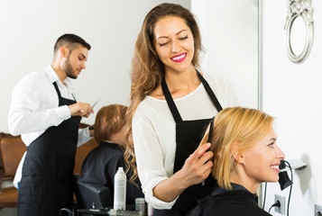 Obraz premium Happy hairdresser doing hairstyle