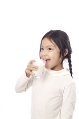 Preschool girl holding a glass with milk