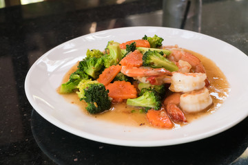 Fried broccoli with prawns on table 