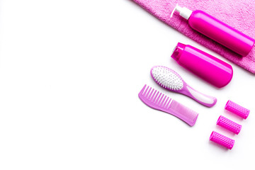 Basic hair care in bathroom. Comb, shampoo, spray, curlers, towel on white background top view copyspace