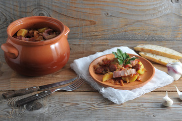 dish cooked in a pot - potatoes, beans, smoked in a clay pot