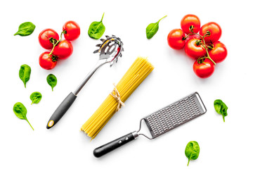 Fototapeta na wymiar Cooking italian pasta. Spaghetti, tomatoes, garlic, basil and cookware on white background top view