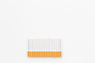 Tobacco. Row of cigarettes on white background top view copyspace