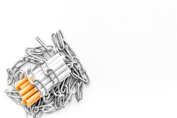 Quit smoking. Cigarettes in chains on white background top view copyspace