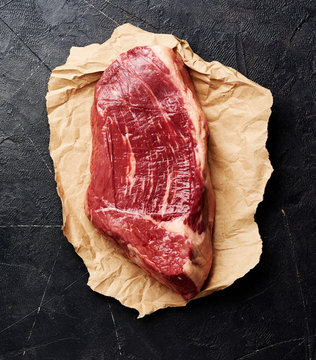 Raw fresh marbled meat Black Angus steak on black background. Top view.