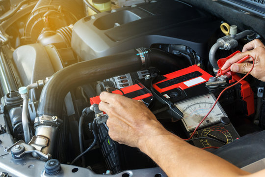 Mechanic Car Service Using  Multimeter  To Check The Voltage Level In A Car Battery