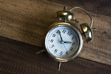 golden time clock - Golden bell clock on a wooden table background