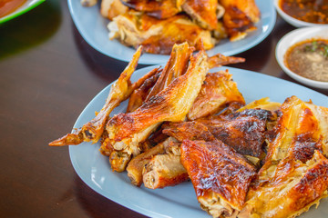 Grilled chicken cut into pieces on a gray table.