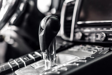 Close-up on automatic transmission lever in modern car. multimedia and navigation control buttons. Car interior details. Transmission shift.