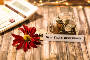 Naklejka na ściany i meble New Year's Resolution money jar savings motivational concept on wooden board 