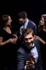stylish young man raising a glass of wine