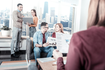 Creative encirclement. Smart busy confident workers having free time in the office communicating and having discussion.