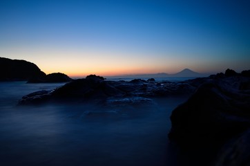Fototapeta na wymiar Mt. Fuji silhouette with reef at sunset slow shutter