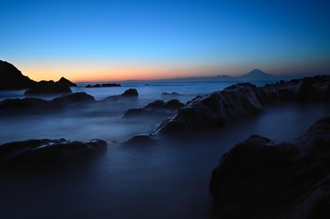 Obraz premium Mt. Fuji silhouette with reef at sunset slow shutter