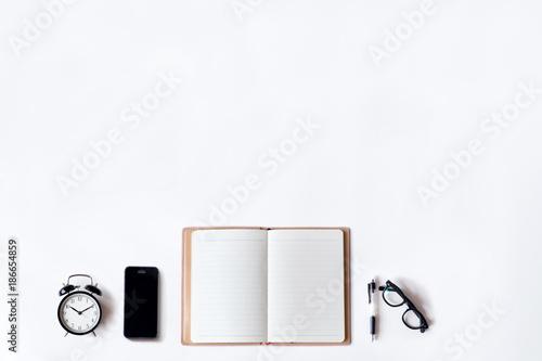 White Office Desk Table With Open Diary Pen Alarm Clock And