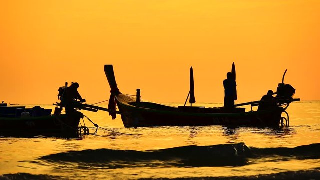 Travel video silhouette long tail boat and The fisherman are maintenance ship. After the boats go out, such as catching the fish. Trips are made every day with  golden light of the Sun  before sunset