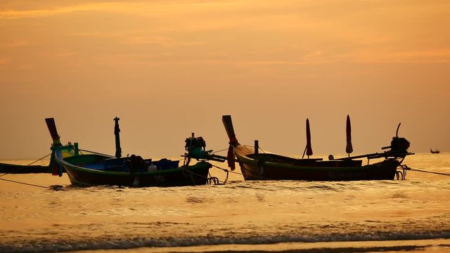 Travel video silhouette long tail boat and The fisherman are maintenance ship. After the boats go out, such as catching the fish. Trips are made every day with  golden light of the Sun  before sunset