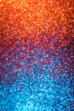 Multicolored orange red and blue shiny abstract blurred festive bokeh lights vertical background