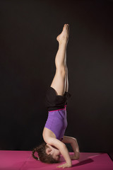Little caucasian girl practing headstand pose