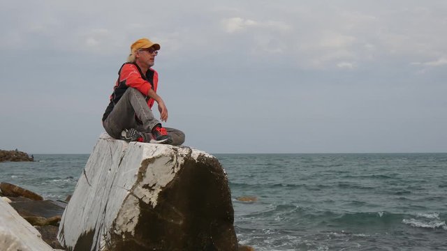 Uomo seduto osserva il mare