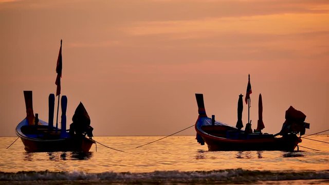 Travel video silhouette long tail boat and The fisherman are maintenance ship. After the boats go out, such as catching the fish. Trips are made every day with  golden light of the Sun  before sunset