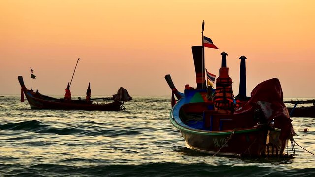 Group of  long tail boat converted to boat excursions floating in the andaman sea with golden light of the Sun before sunset and  boat background in travel or transportation concept.