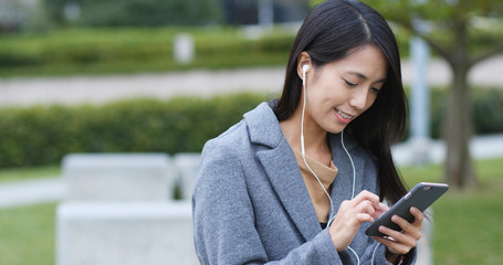 Woman listen to music on cellphone at outdoor