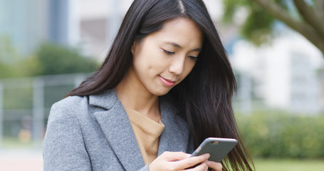 Woman look at cellphone in park