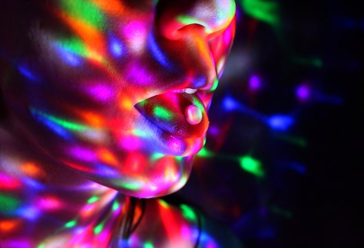 A young woman has ecstasy on her tongue in a night club.
