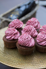 Vintage tray with beautiful cupcakes on wooden background, closeup